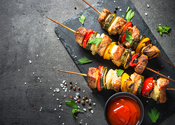 Grilled shish kebab with vegetables  on black.